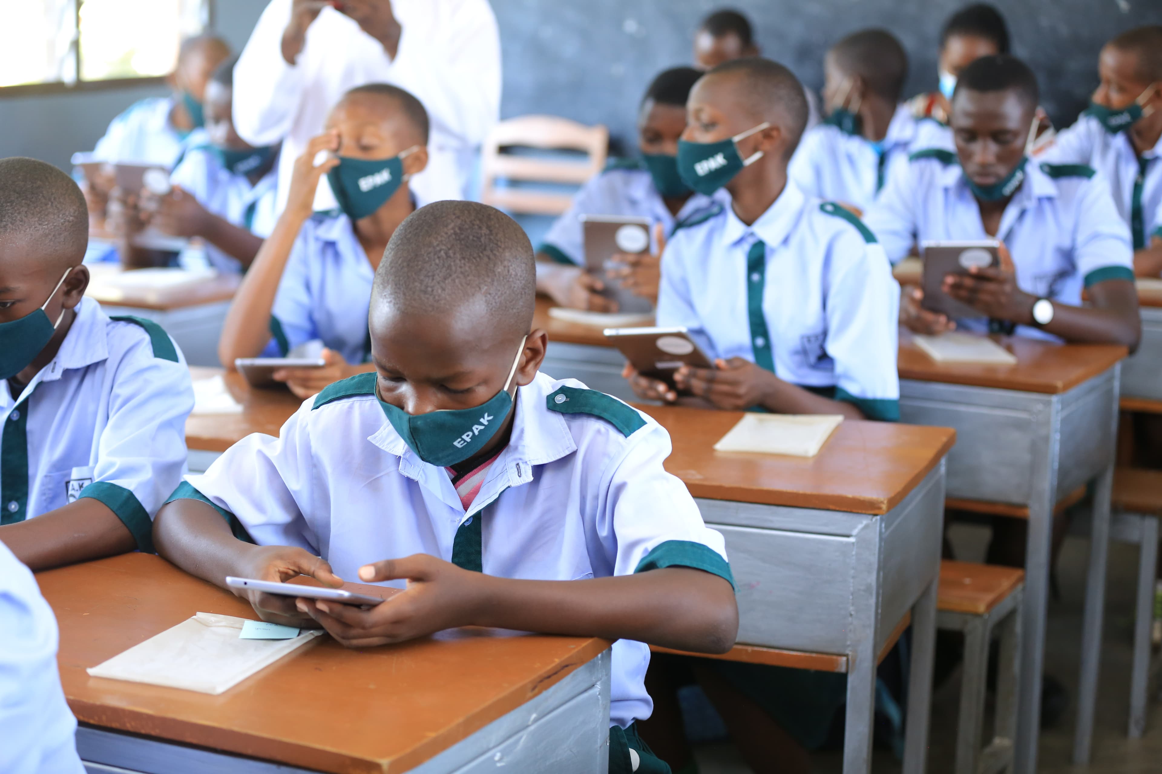 Multiple Students Holding tablets with SomaBox web interface open