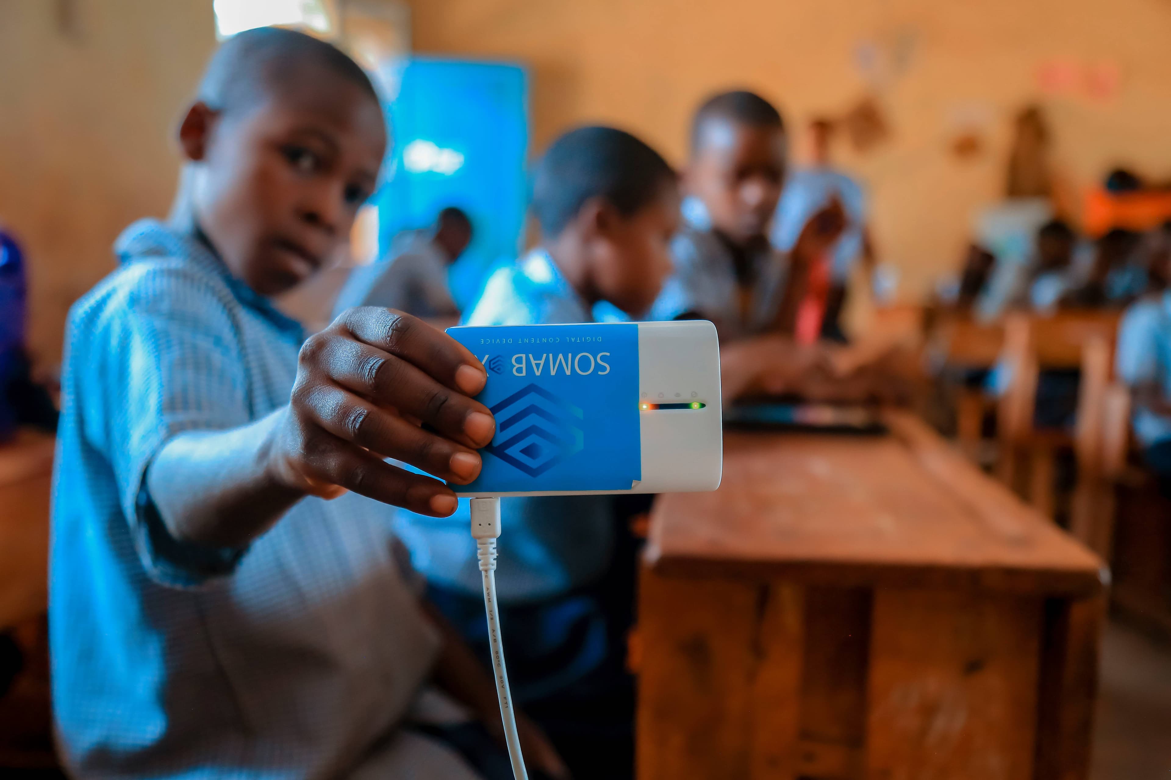 A primary student holding SomaBox